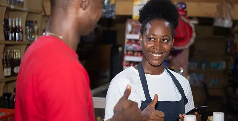 Sub-Saharan Africa remains the most active region for mobile money, with East and West Africa seeing the highest growth in registered accounts and monthly usage. (Image source: Adobe Stock) Two_Africa's_young_people_show_thumbs_up_while_mobile_money_transaction